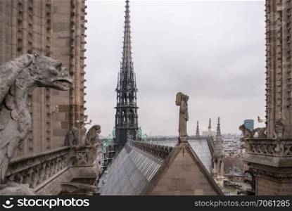 Famous figures of gargoyles and angel of Notre Dame over Paris aerial. Angel and many gargoyles