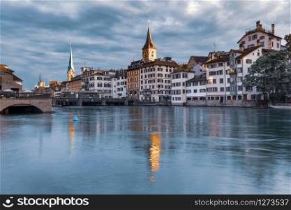 Famous Fraumunster and Church of St Peter with reflections in river Limmat at sunrise in Old Town of Zurich, the largest city in Switzerland. Zurich, the largest city in Switzerland
