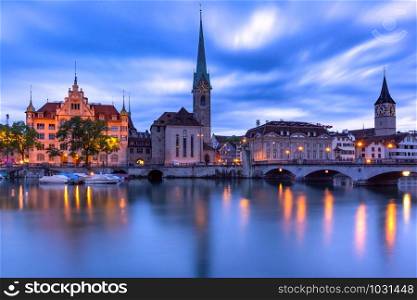 Famous Fraumunster and Church of St Peter with their reflections in river Limmat during morning blue hour in Old Town of Zurich, the largest city in Switzerland. Zurich, largest city in Switzerland