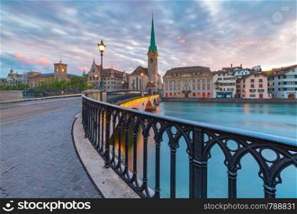 Famous Fraumunster church and Munsterbrucke bridge over river Limmat at sunrise in Old Town of Zurich, the largest city in Switzerland. Zurich, the largest city in Switzerland