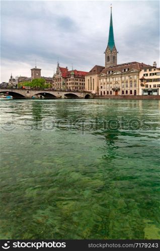 Famous Fraumunster church and river Limmat on the cloudy day in Old Town of Zurich, the largest city in Switzerland. Zurich, largest city in Switzerland