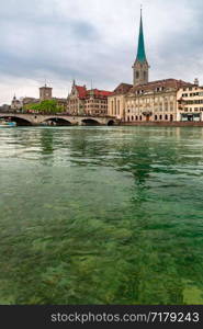 Famous Fraumunster church and river Limmat on the cloudy day in Old Town of Zurich, the largest city in Switzerland. Zurich, largest city in Switzerland