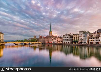 Famous Fraumunster church with its reflections in river Limmat at sunrise in Old Town of Zurich, the largest city in Switzerland. Zurich, the largest city in Switzerland