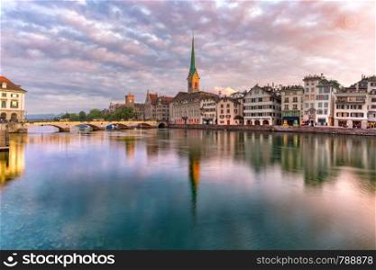 Famous Fraumunster with its reflections in river Limmat at sunrise in Old Town of Zurich, the largest city in Switzerland. Zurich, the largest city in Switzerland