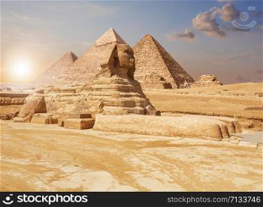 Famous Giza Sphinx and the Pyramids on the background, Egyptian desert.. Famous Giza Sphinx and the Pyramids on the background, Egyptian desert