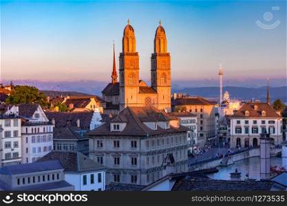 Famous Grossmunster churche along river Limmat at sunset in Old Town of Zurich, the largest city in Switzerland. Grossmunster churche in Zurich, Switzerland