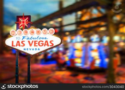 Famous Las Vegas sign at night with casino blur background.. Famous Las Vegas sign