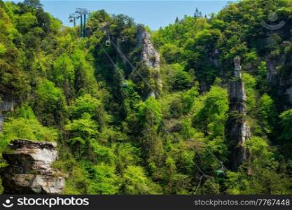 Famous tourist attraction of China - Zhangjiajie stone pillars cliff mountains with cable railway car lift at Wulingyuan, Hunan, China. With camera pan. Zhangjiajie mountains, China