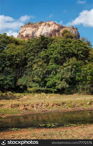 Famous tourist landmark of Sri Lanka - ancient Sigiriya rock (Lion rock) with palace fortress ruins on top in Sigiriya, Sri Lanka. UNESCO World Heritage Site. Famous tourist landmark - ancient Sigiriya rock, Sri Lanka