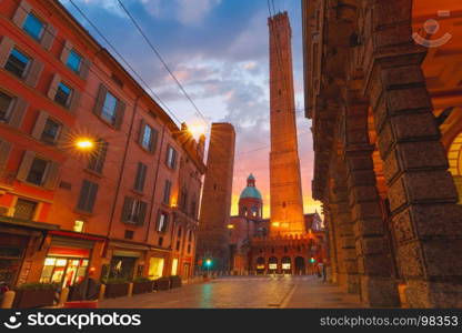 Famous Two Towers of Bologna at sunrise, Italy. Two Towers, Asinelli and Garisenda, both of them leaning, symbol of Bologna, statue of San Petronius and Church of Saints Bartholomew and Gaetano at sunrise, Bologna, Emilia-Romagna, Italy