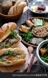 Famous Vietnamese food is banh mi thit, popular street food from bread stuffed with raw material: pork, ham, pate, egg and fresh herbs as scallions, coriander, carrot, cucumber, chilli.