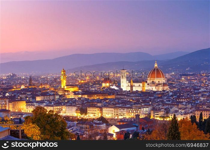 Famous view of Florence at night, Italy. Beautiful panoramic view of Duomo Santa Maria Del Fiore and tower of Palazzo Vecchio during evening blue hour in Florence, Tuscany, Italy