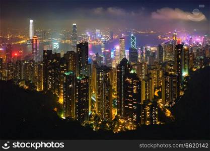 Famous view of Hong Kong - Hong Kong skyscrapers skyline cityscape view from Victoria Peak illuminated in the evening blue hour. Hong Kong, China. Hong Kong skyscrapers skyline cityscape view