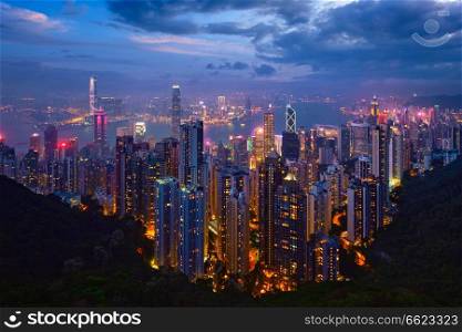 Famous view of Hong Kong - Hong Kong skyscrapers skyline cityscape view from Victoria Peak illuminated in the evening blue hour. Hong Kong, China. Hong Kong skyscrapers skyline cityscape view