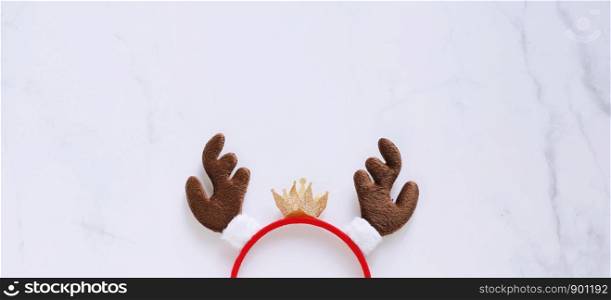 Fancy headband with reindeer antler decorative shape for christmas party and celebration on white marble background, banner style for text