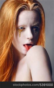 Fantasy. Expression. Eccentric Woman with White Painted Skin and Gold Tears Licking her Shoulder