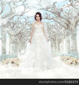 Fantasy. Matrimony. Bride in White Dress over Frozen Winter Trees and Snowflakes
