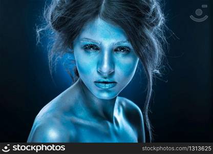 Fantasy woman with blue frost makeup and skin. Ice queen, body art, fluorescent cosmetics