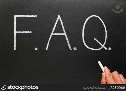 FAQ, frequently asked questions abbreviation, written on a blackboard.