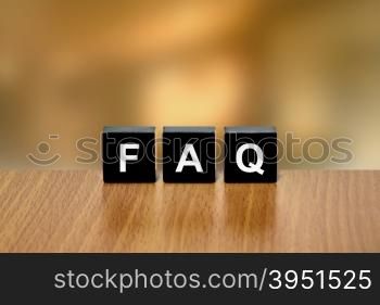 FAQ or Frequently asked questions on black block with blurred background