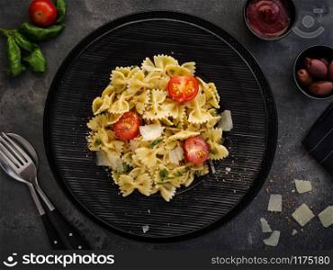 Farfalle pasta with parmesan, basil and cherry tomatoes. Italian Cuisine. Top view.