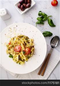 Farfalle pasta with parmesan, basil and cherry tomatoes. Italian Cuisine. Top view.