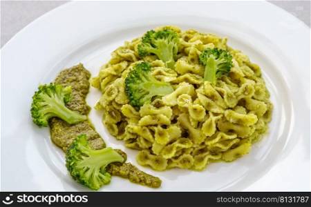 Farfalline pasta with pesto and broccoli on the plate