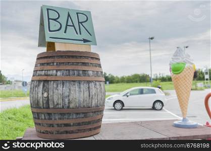 Farm cart with large plastic ice cream, and a wine barrel to indicate a bar