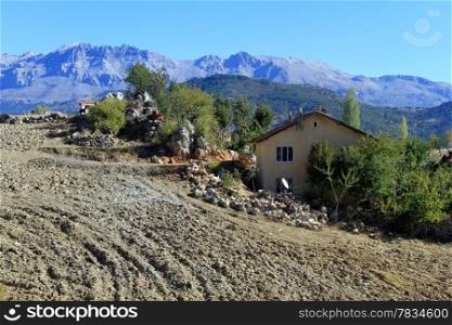 Farm field and house near mountain in Turkey