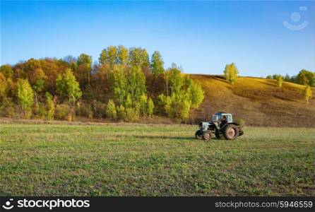 Farm tractor on the field in Europe in the fall