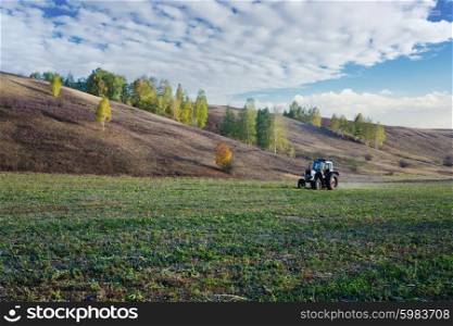 Farm tractor on the field in Europe in the fall