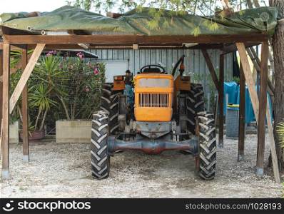 Farm tractor parked in the garage. Vintage tractor