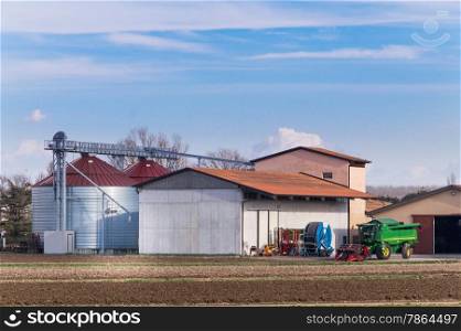 Farm with silos, various agricultural tools and thresher
