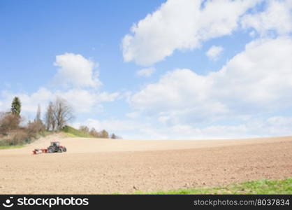 Farm work. Tractor compresses the soil after planting with rollers.