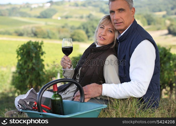 Farmer and wife drinking wine in a vineyard