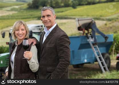 Farmer and wife in front of equipment