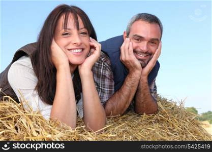 Farmer and wife laying in hay