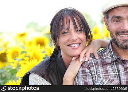 Farmer and wife stood in field of sunflowers