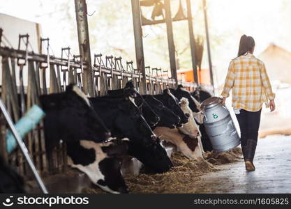 farmer asian woman are holding a container of milk on his farm