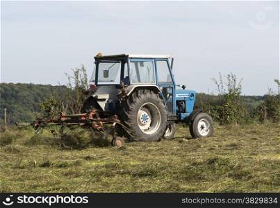 farmer at work with tractor mowing grass
