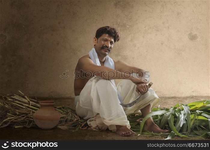 Farmer holding sickle hand-held with crops