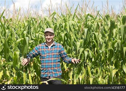 Farmer in corn field looking at camera smiling