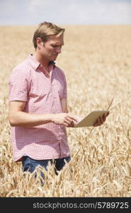 Farmer Inspecting Crops In Field Using Digital Tablet