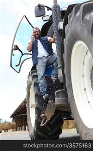 Farmer on a tractor using a mobile phone