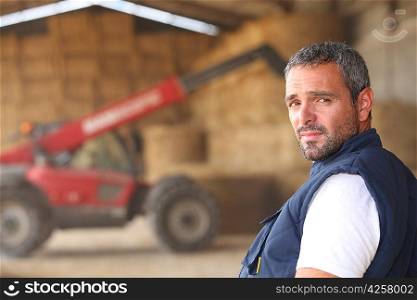 farmer posing in front of a tractor