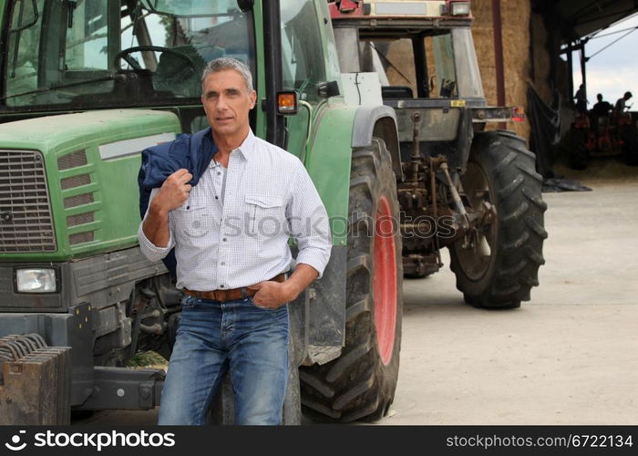 farmer posing near tractors