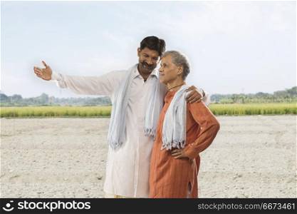 Farmer showing paddy field to his father