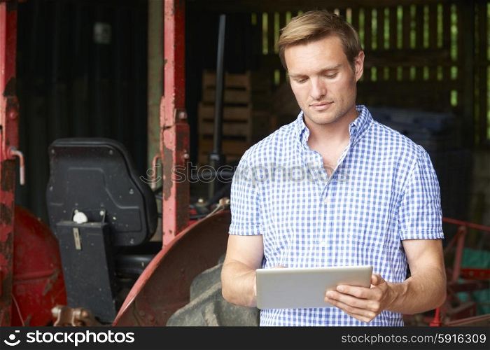 Farmer With Old Fashioned Tractor Using Digital Tablet