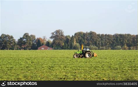 farmer with tractor on the green field