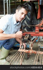 Farmer Working On Agricultural Equipment In Barn